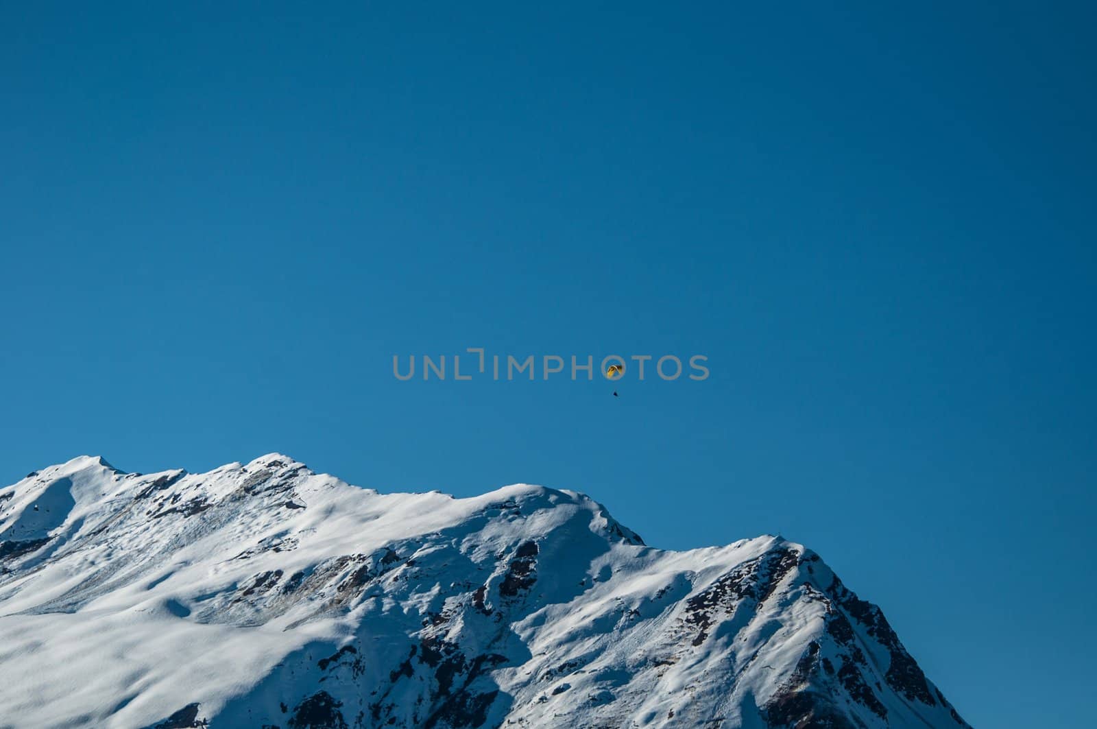 Beautiful winter mountain panorama with paraglider in Montafon, Austria