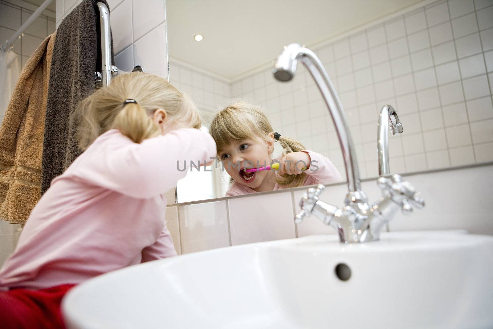 Baby Girl with toothbrush in the bathroom