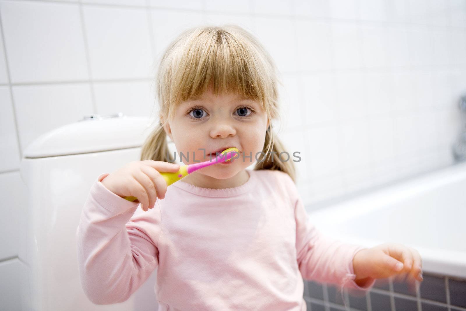 Baby Girl with toothbrush in the bathroom