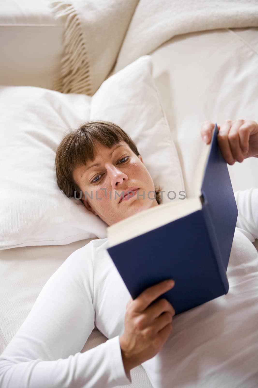 Woman in the sofa reading a book