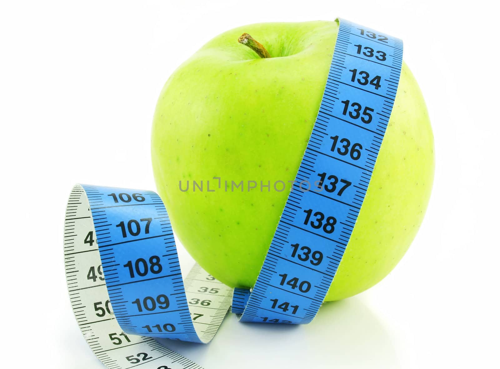 Bright green apple and measuring tape isolated on a white background