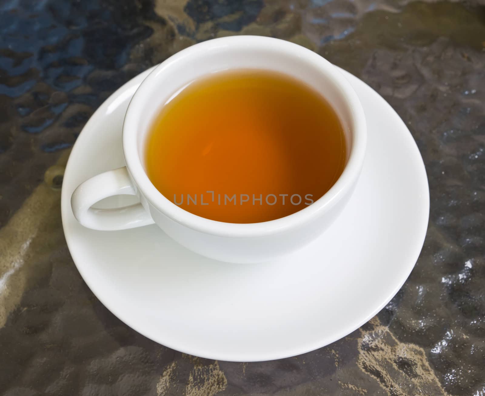 cup of tea on glass table by tungphoto