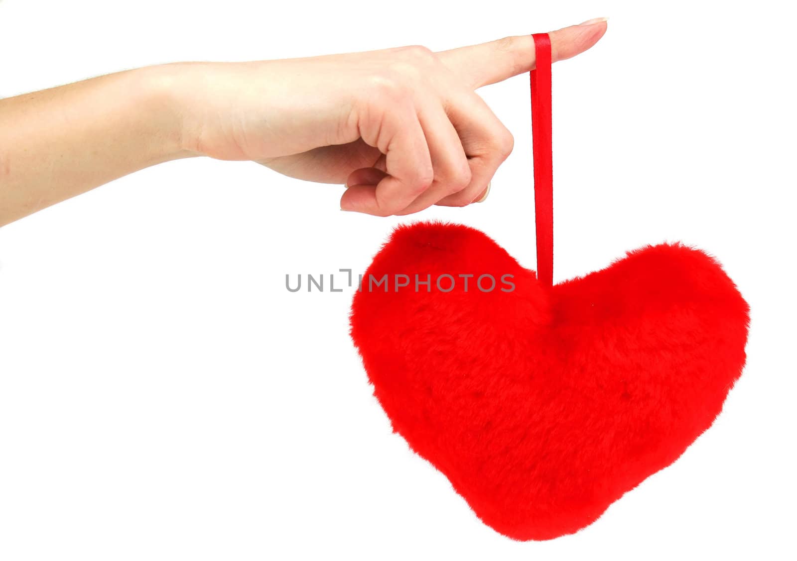 Close-up of red wooden heart hanging down from female hand (isolated)