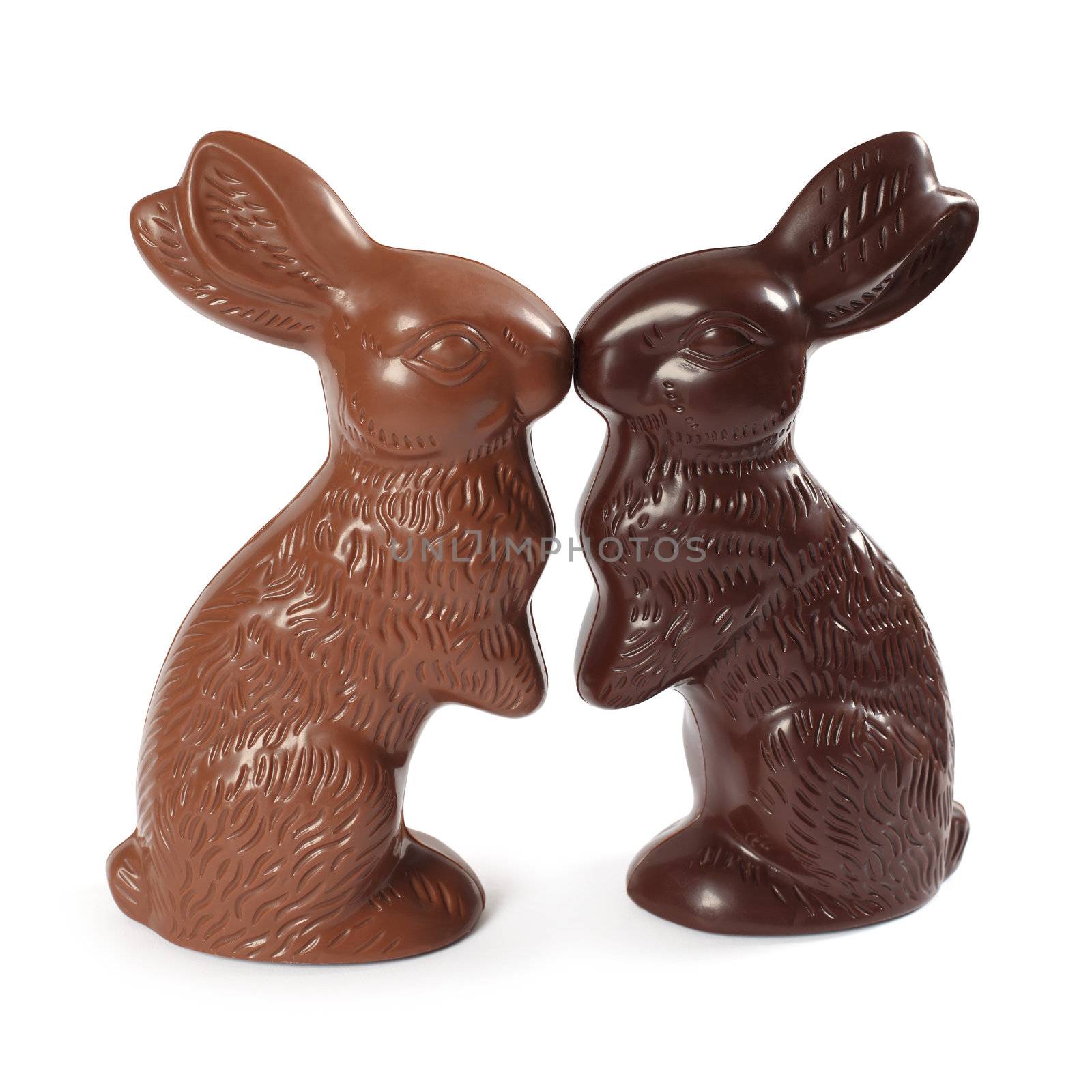 Photo of two chocolate Easter bunnies kissing, one milk chocolate and one dark chocolate. Clipping Path included.