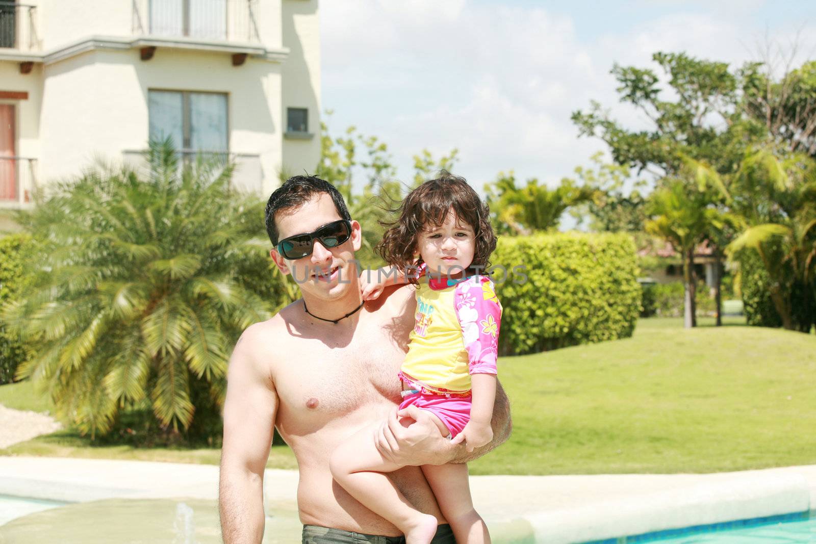 Father and daughter beside the swimming pool by dacasdo