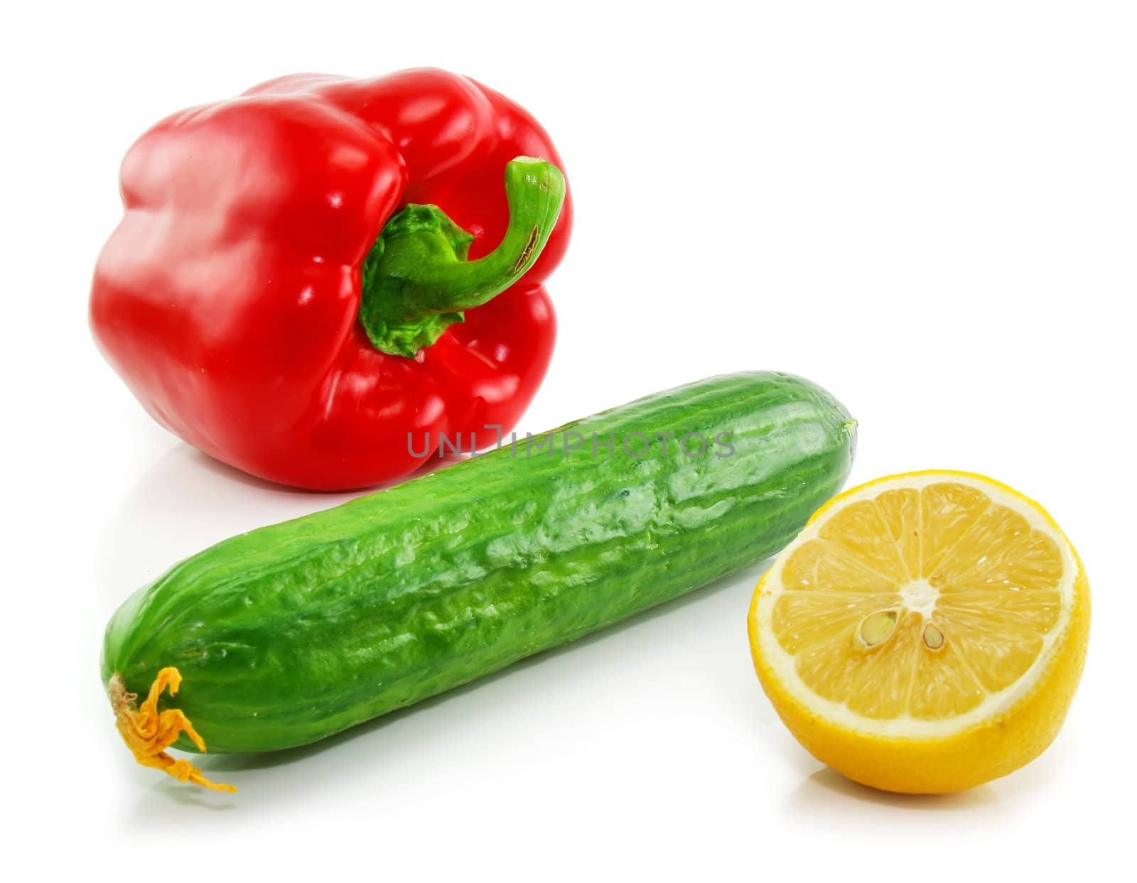Green cucumber, red paprika and yellow lemon isolated on a white background