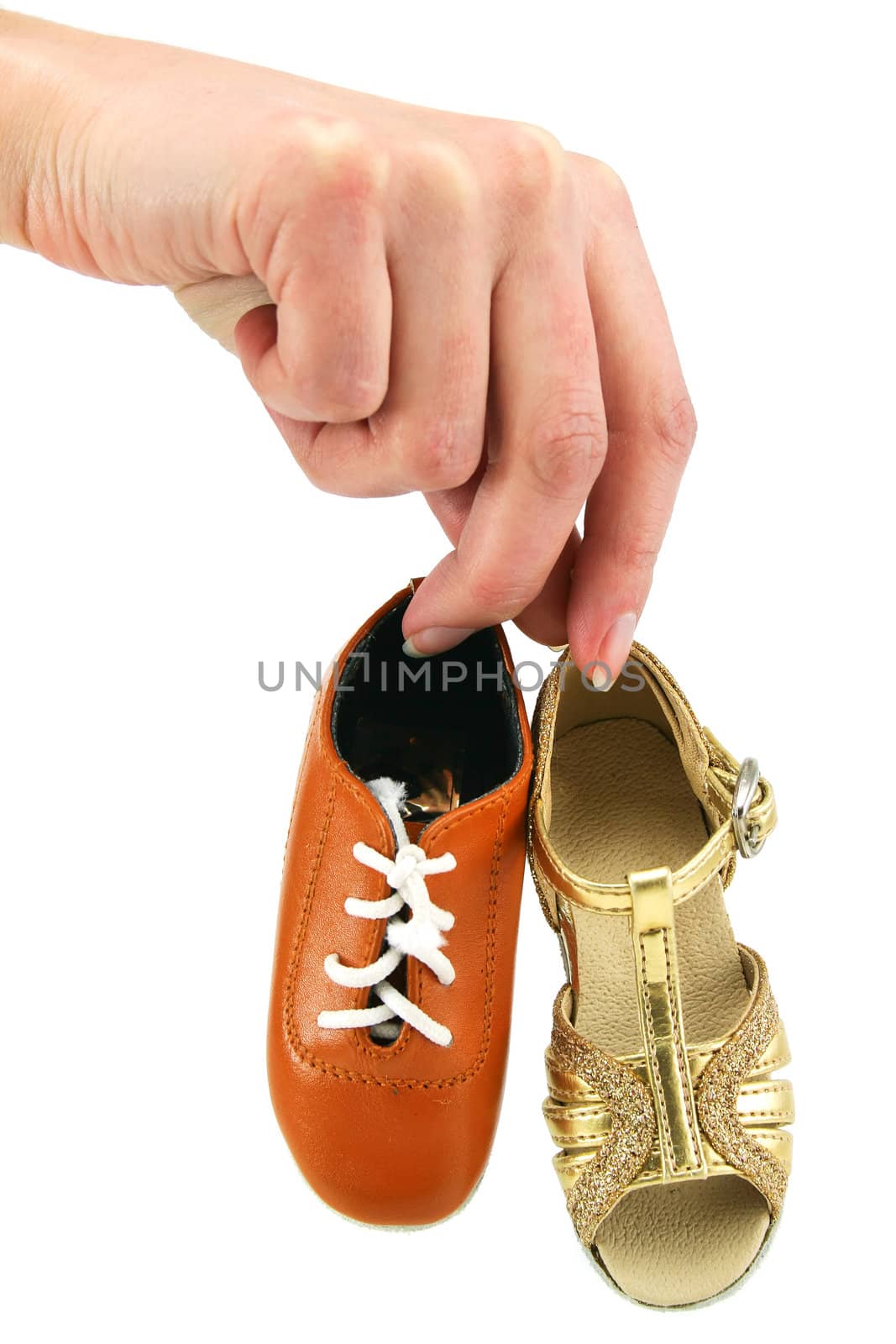 Female hand holds tiny dancing shoes by alphacell