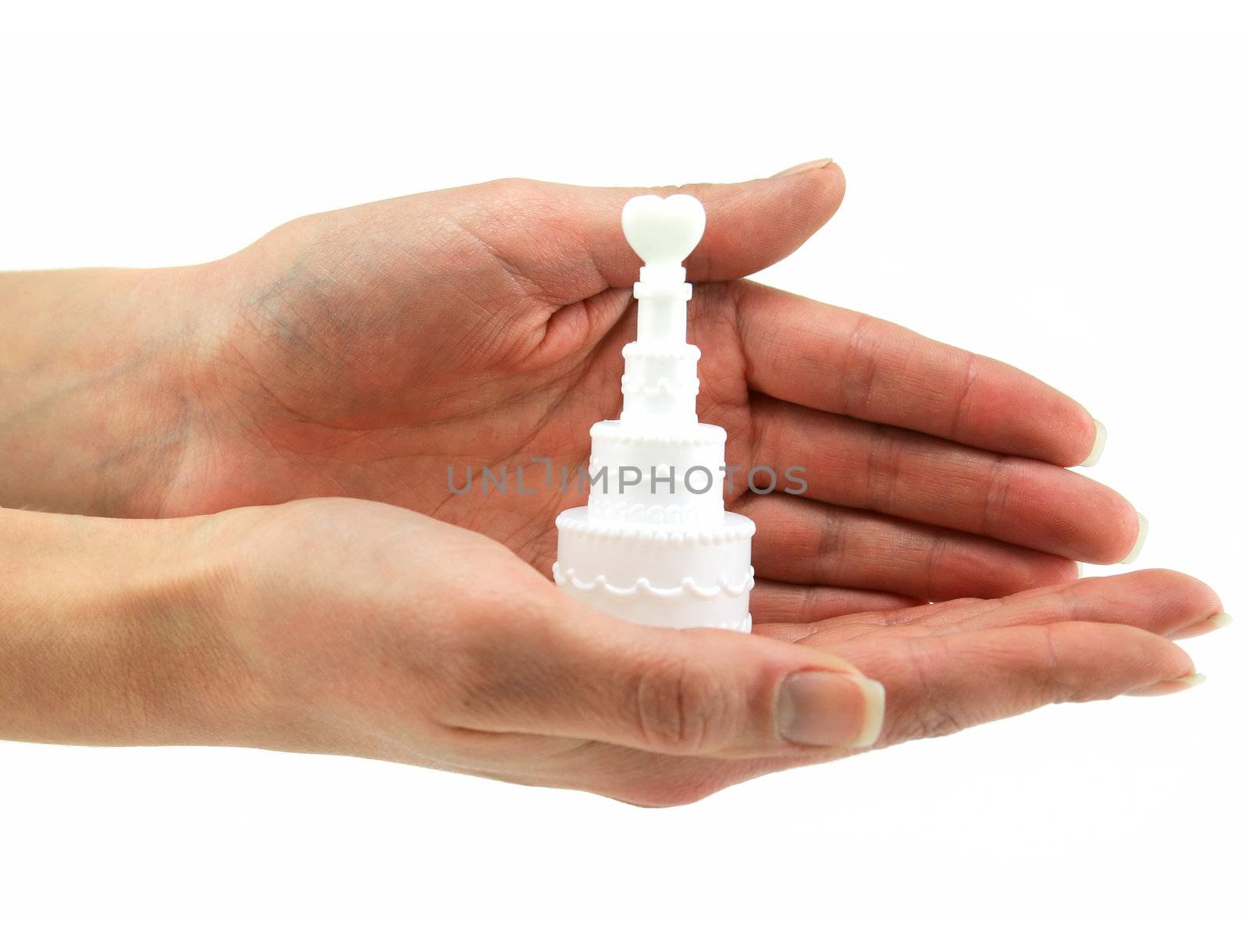 Female hands holds small wedding cake isolated on a white background