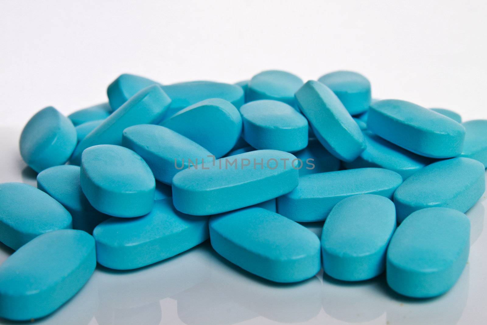 a bunch of blue pills on a white background