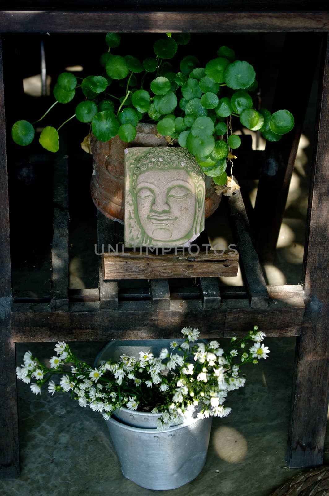 Decorative Buddha art at wooden table with nice flower and plant