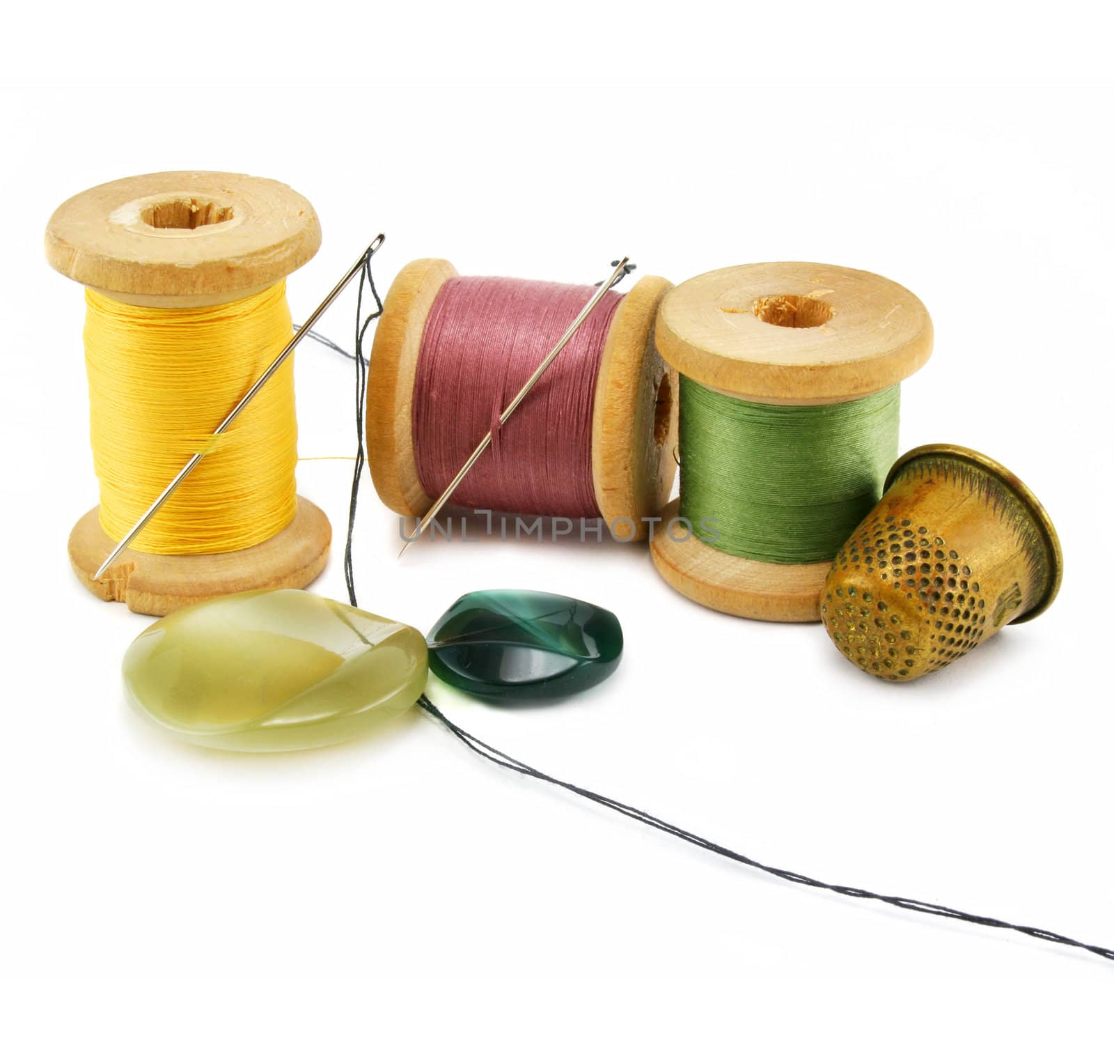 Spool of thread, thimble and needle isolated on a white background