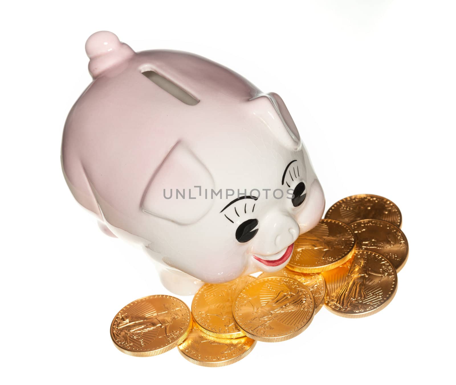 Gold eagle coins surrounding a piggy bank and isolated against white