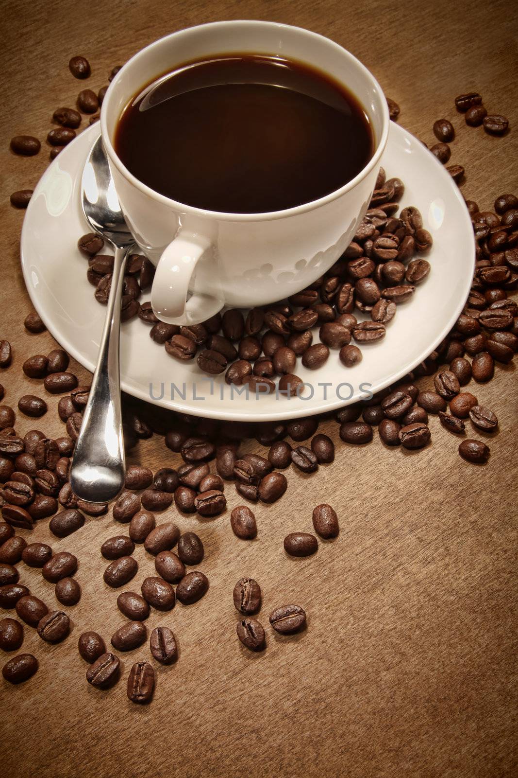 Cup of coffee and beans on wood background