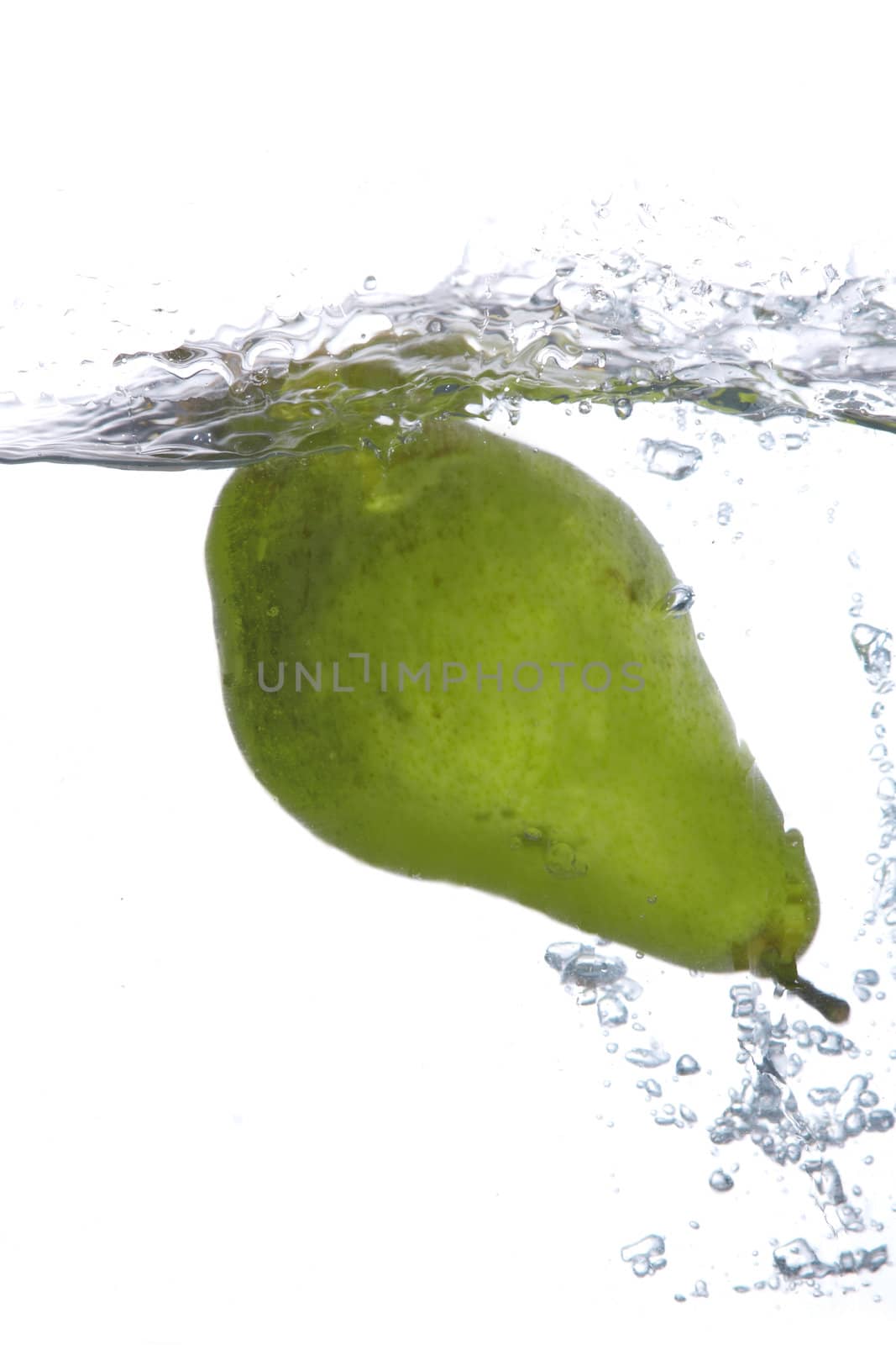 Green pear falling in water