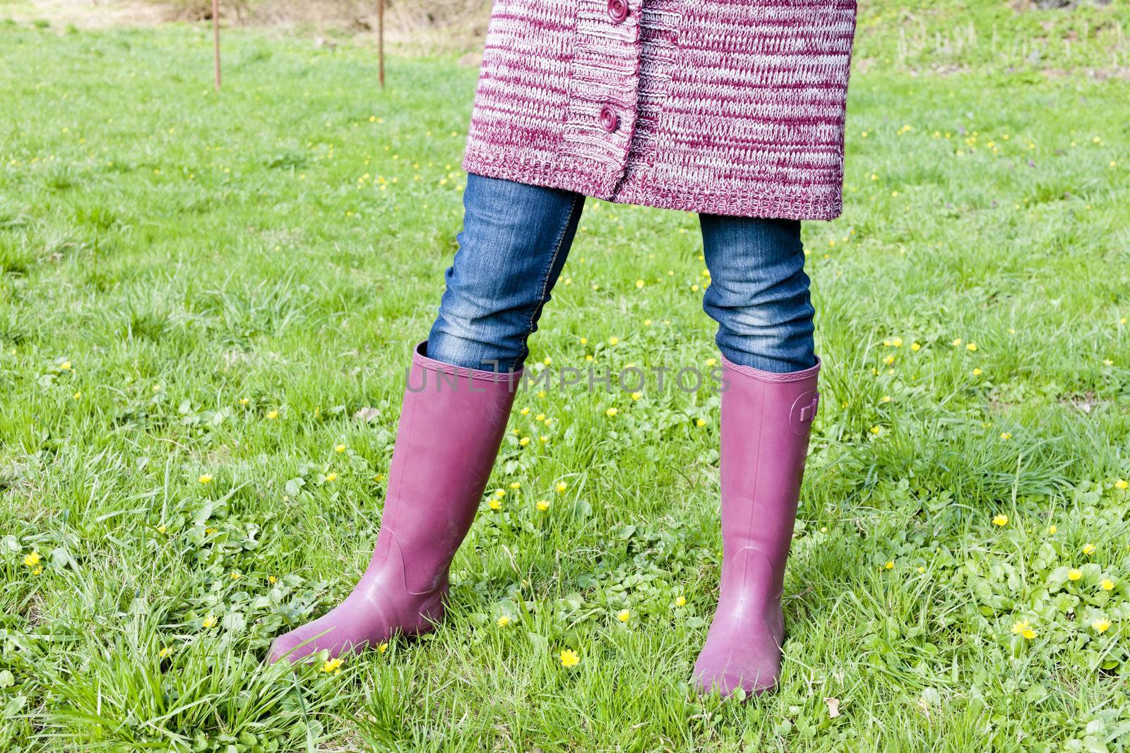 detail of woman wearing rubber boots on spring meadow by phbcz