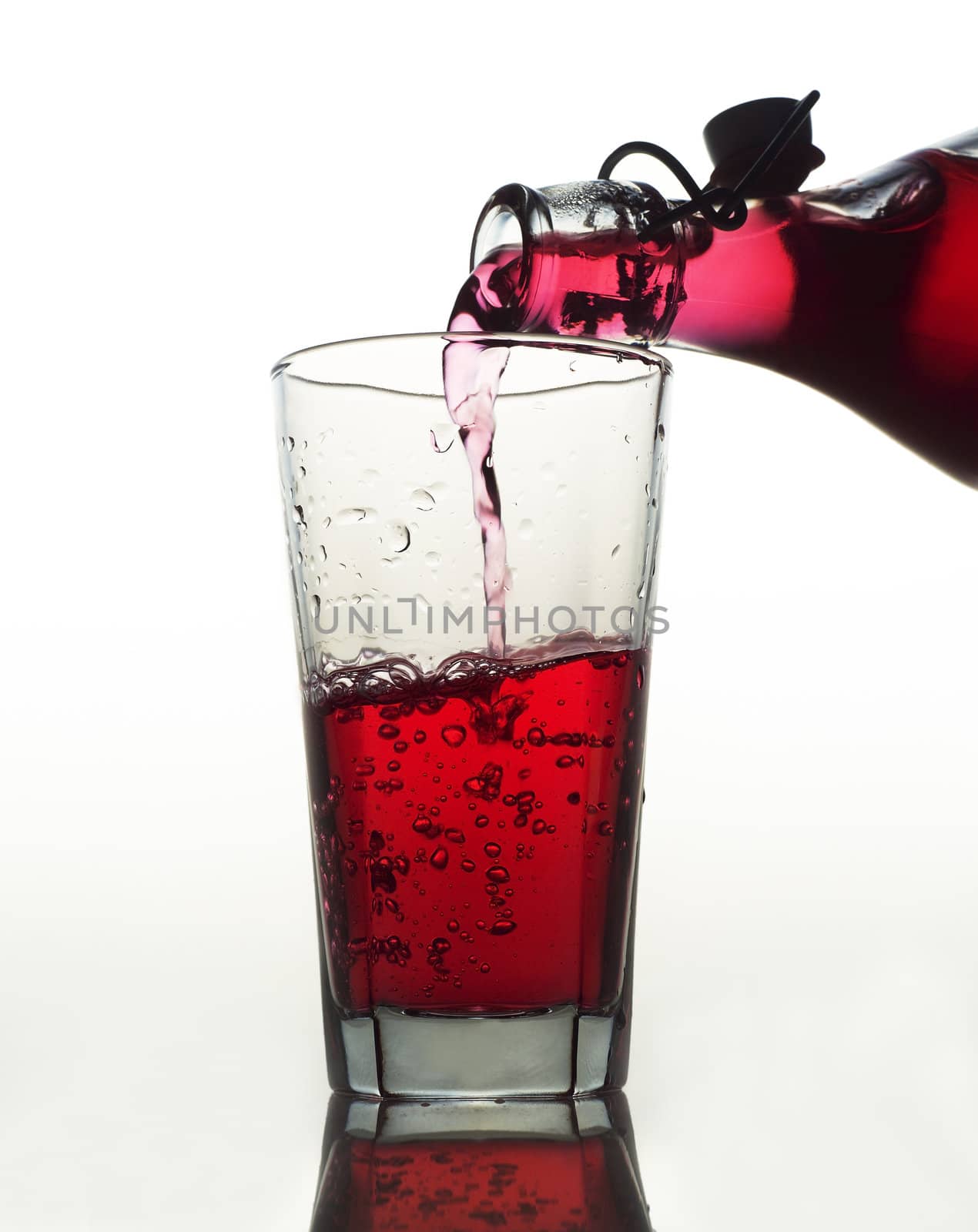 Pouring Red Lemonade in a glass on white background