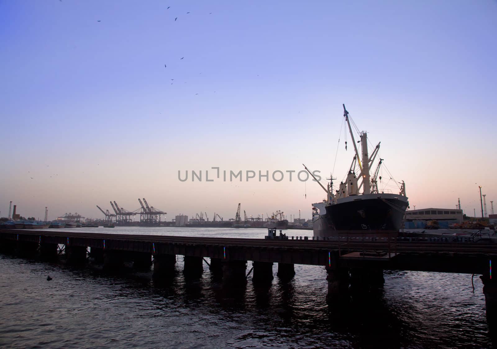 Cargo ship in the harbor at sunset  by haiderazim