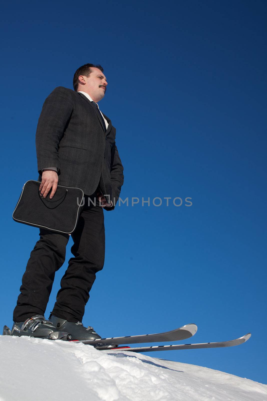 Man in busines sute on ski witn folder