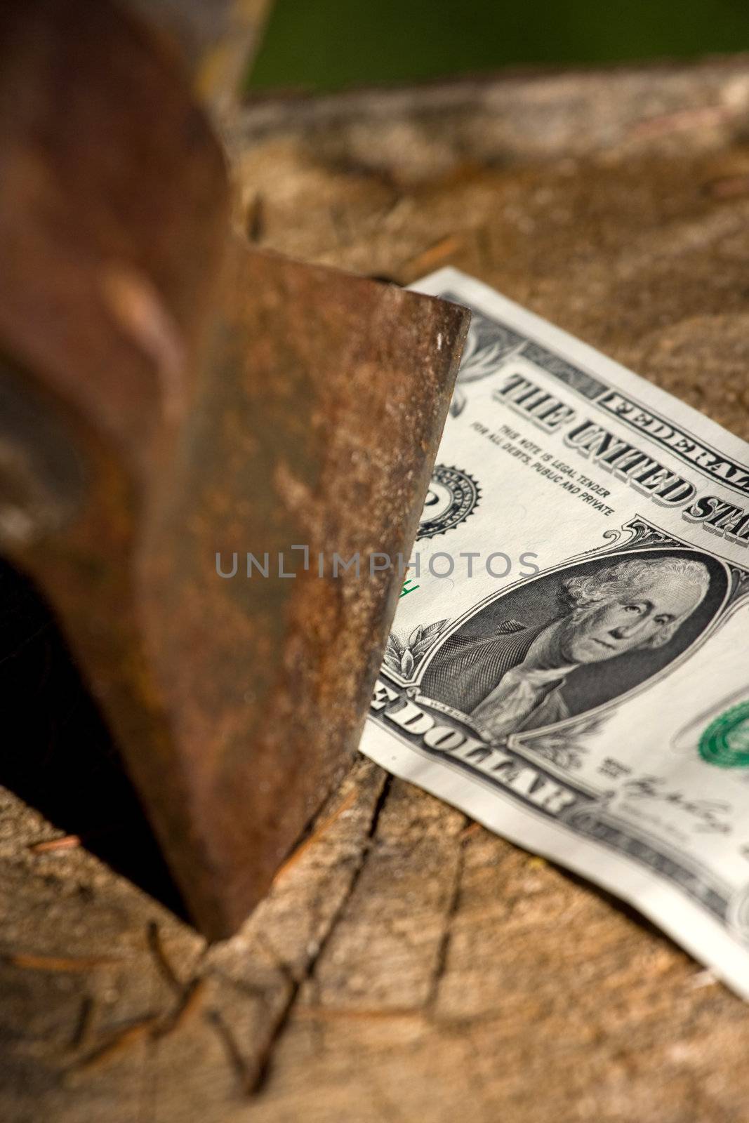 A 1 dollar banknote being cut with an axe