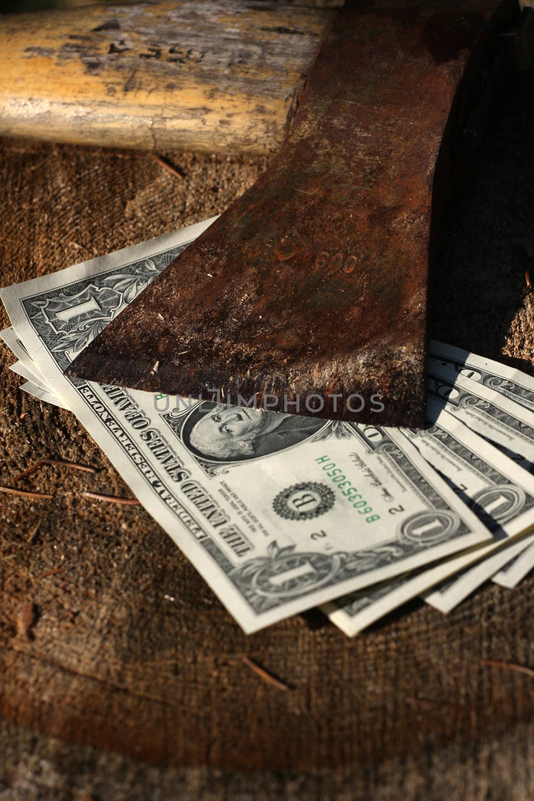 Four dollar bills under sharp old axe