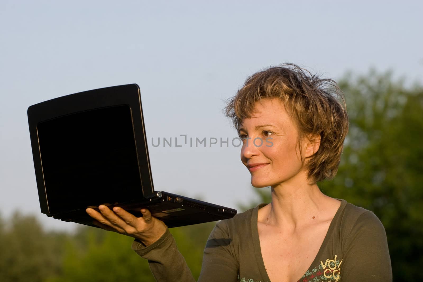 Woman with notebook lying on the grass in park