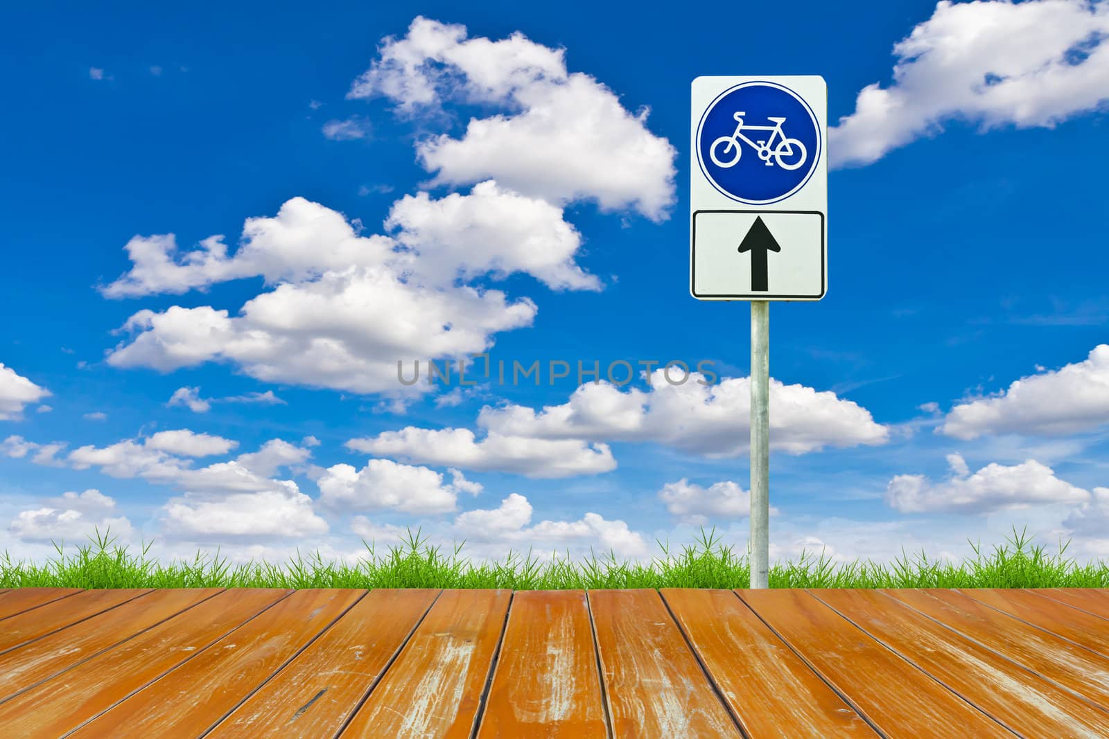 wood bicycle way and sign against blue sky