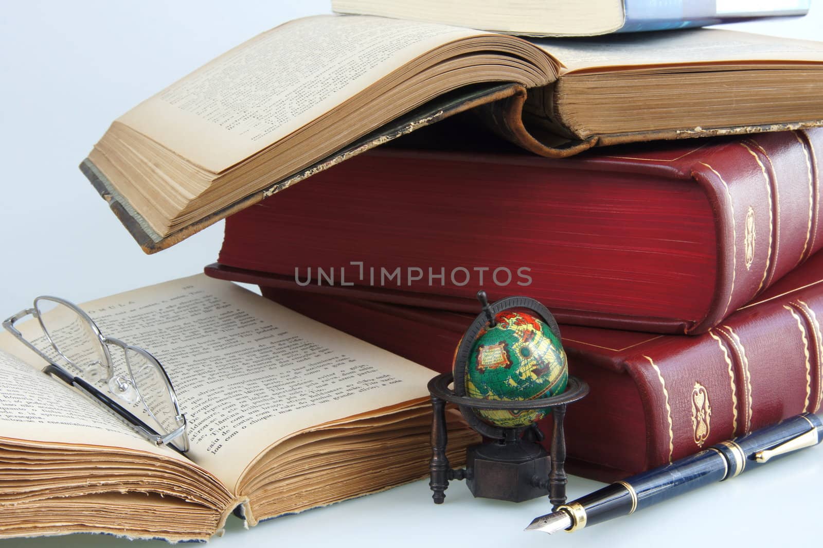 Open and closed books with glasses, globe and fountain pen