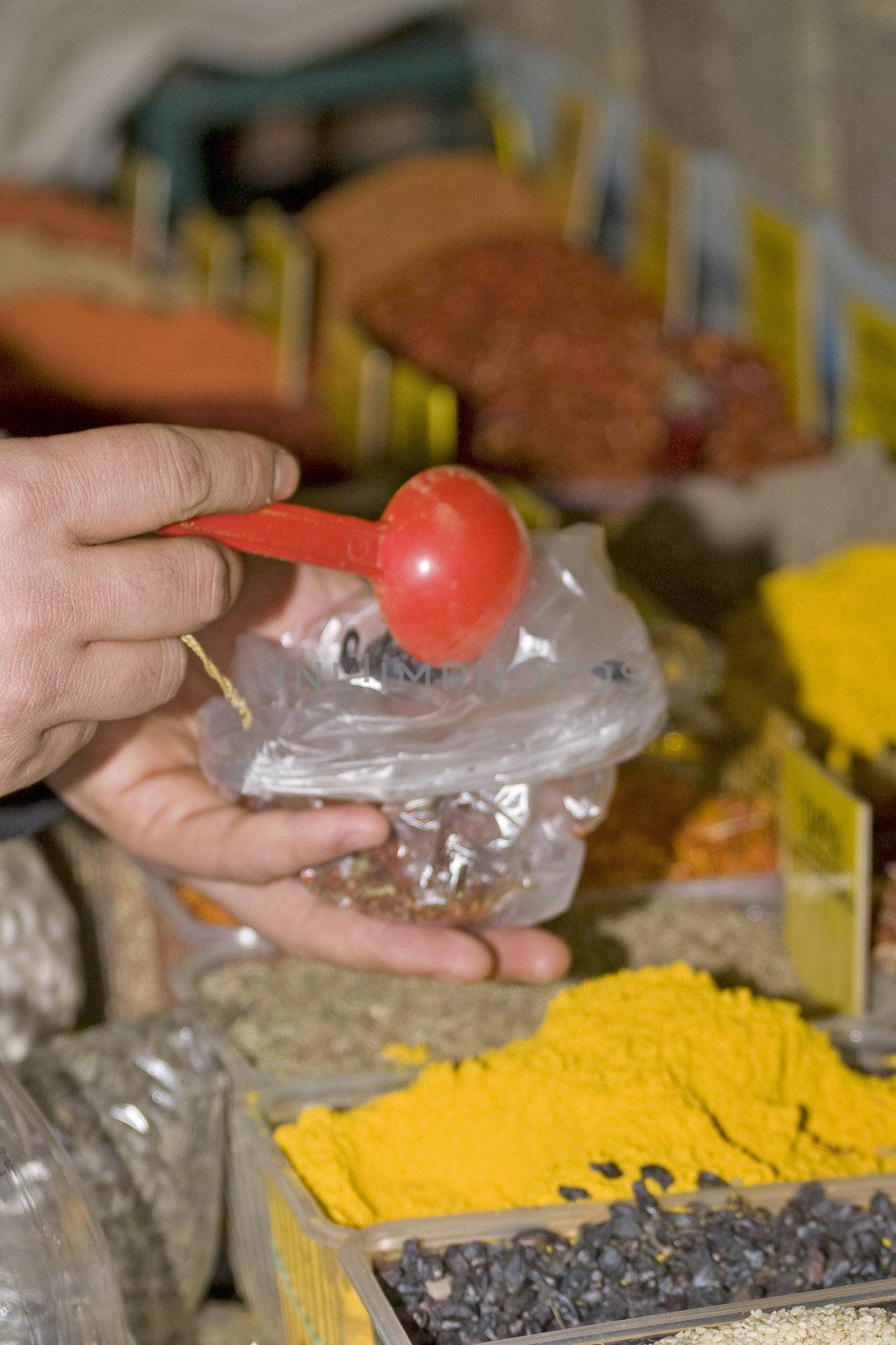 The person fills spices in a package in the market