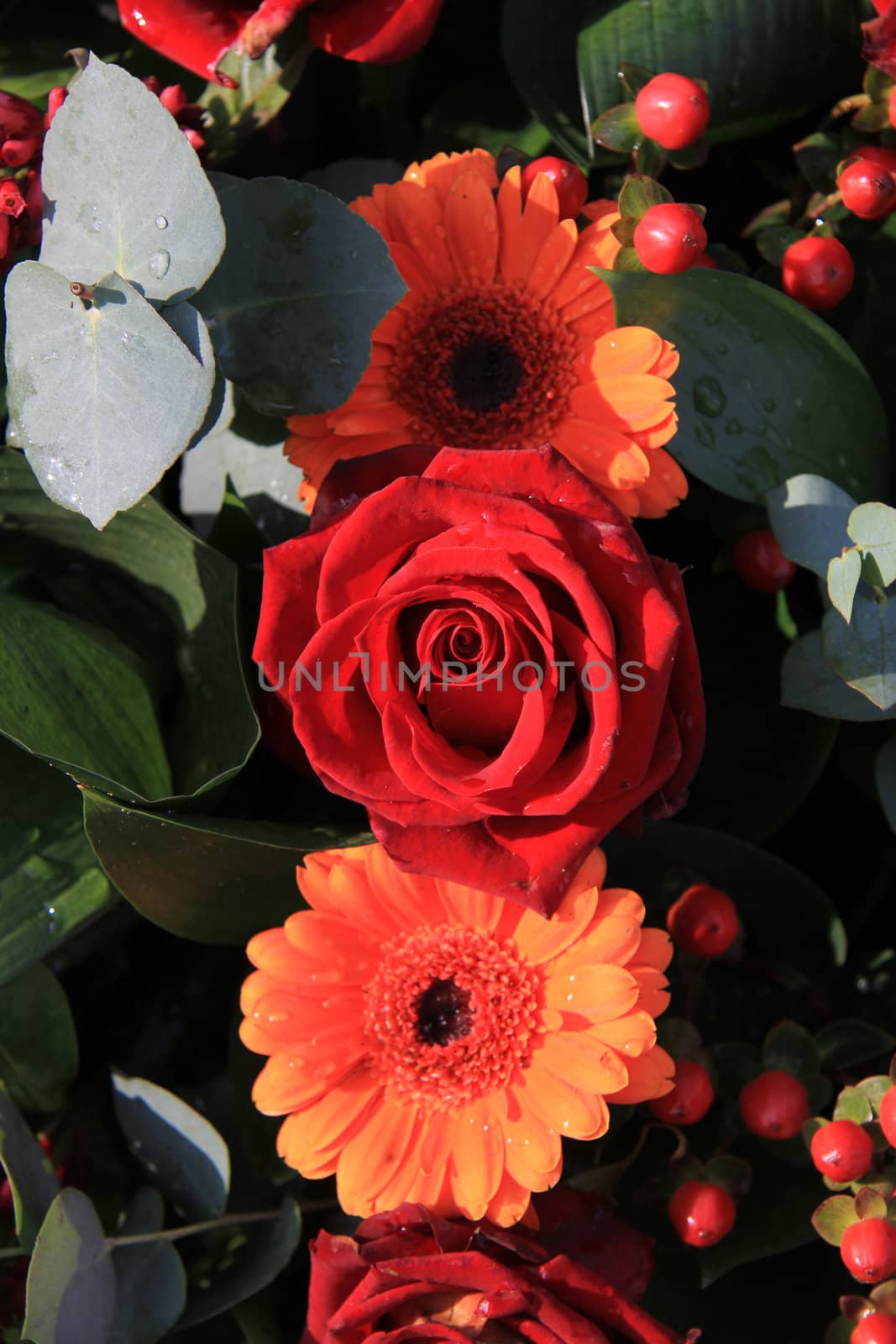 Red and orange flower arrangement by studioportosabbia