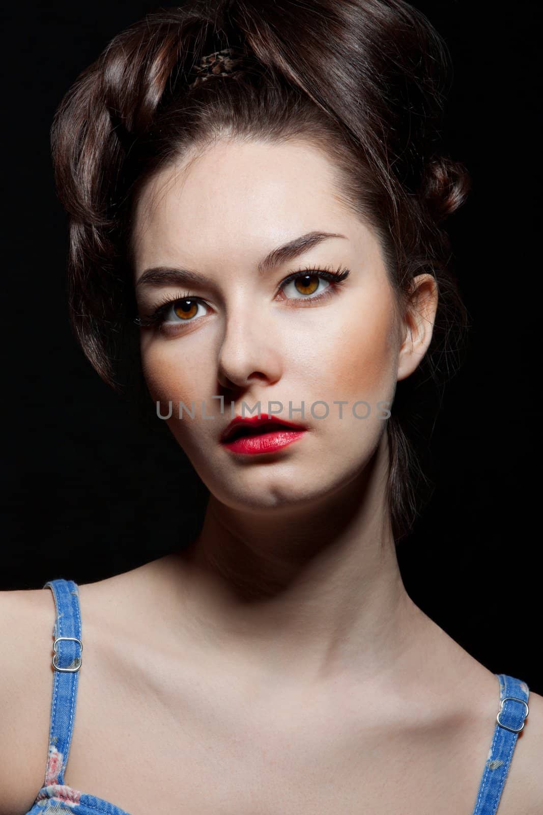 Expressive fashion studio shot of young and beautiful woman on dark background. (Professional makeup and hair style).