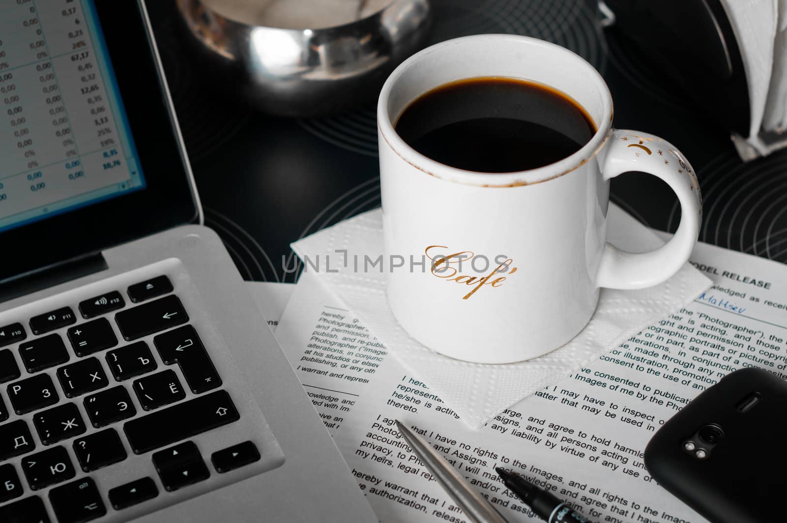 Mobile workplace in cafe with documents, laptop, phone and coffee cup