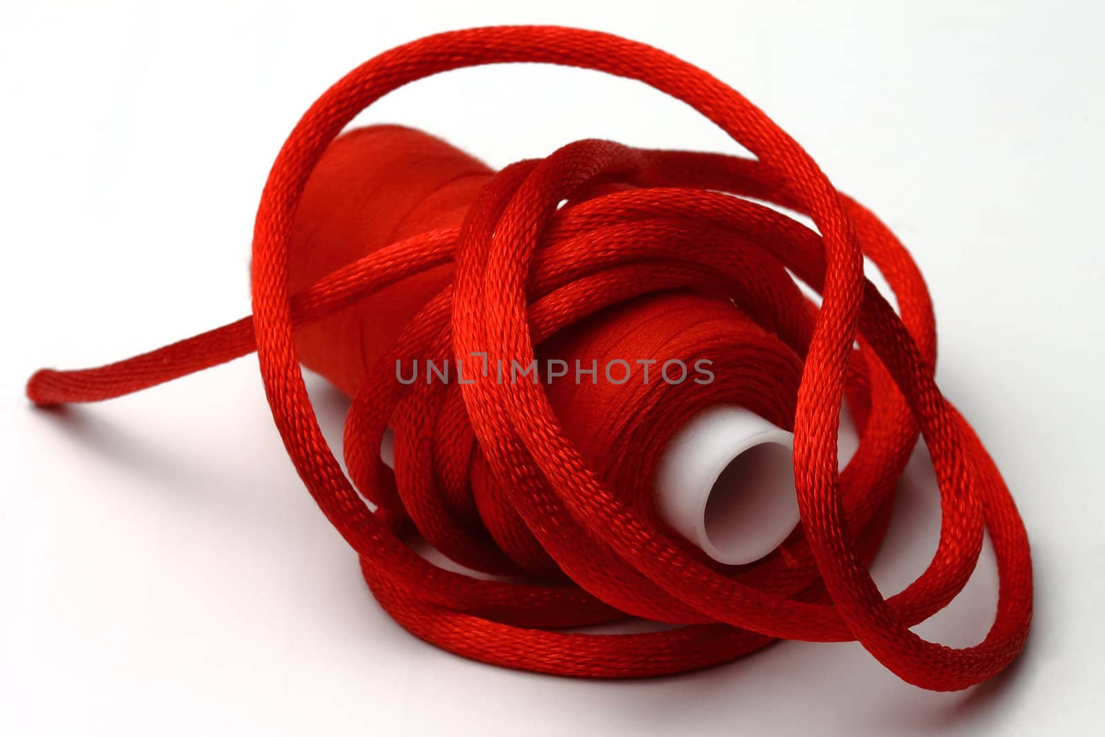 The red coil of threads and red band on a 
white background
