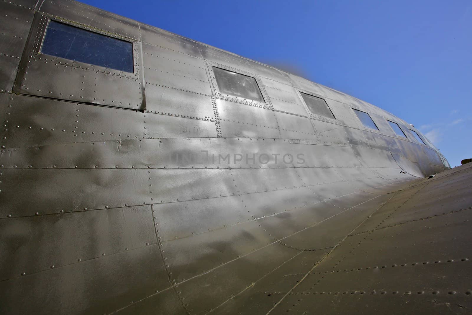 WW II transport airplane, the C-47 showing dramatic contours with blue sky background