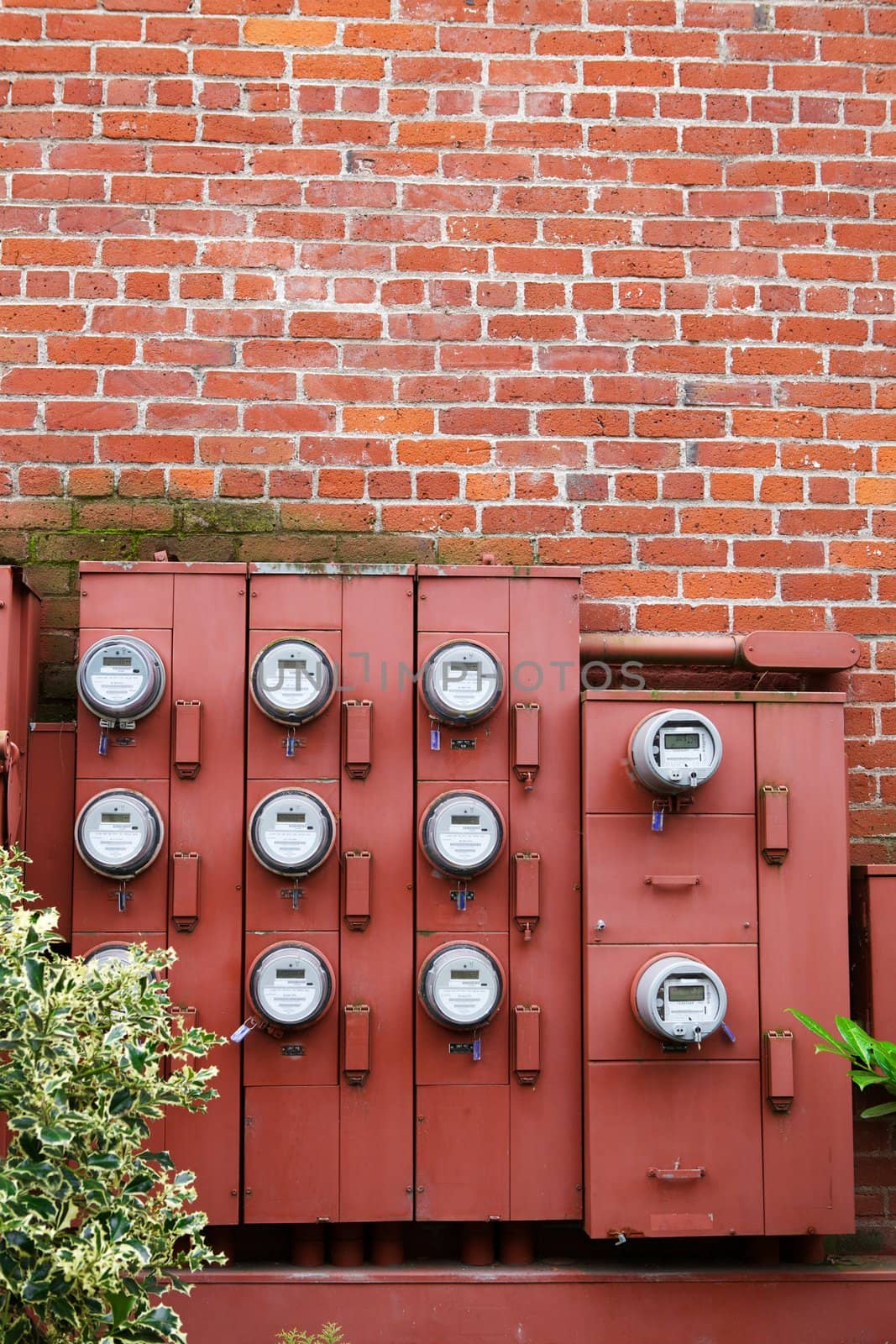 Ten Electric Meters on the red brick wall of an apartment building