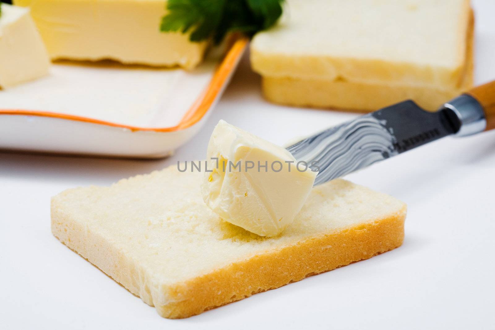 Stock photo: an image of yellow butter on bread and a knife