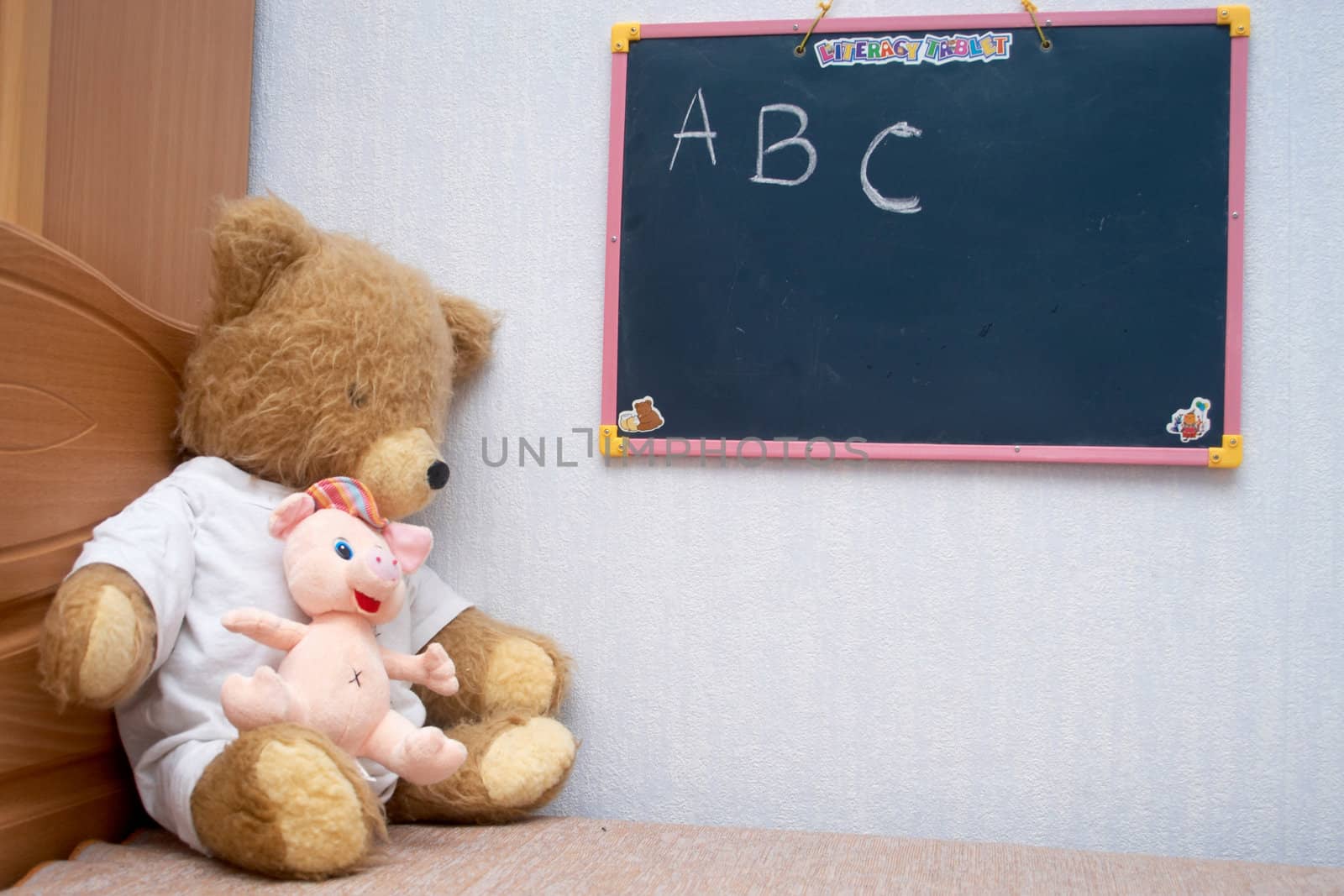 Plush bear sitting at the blackboard