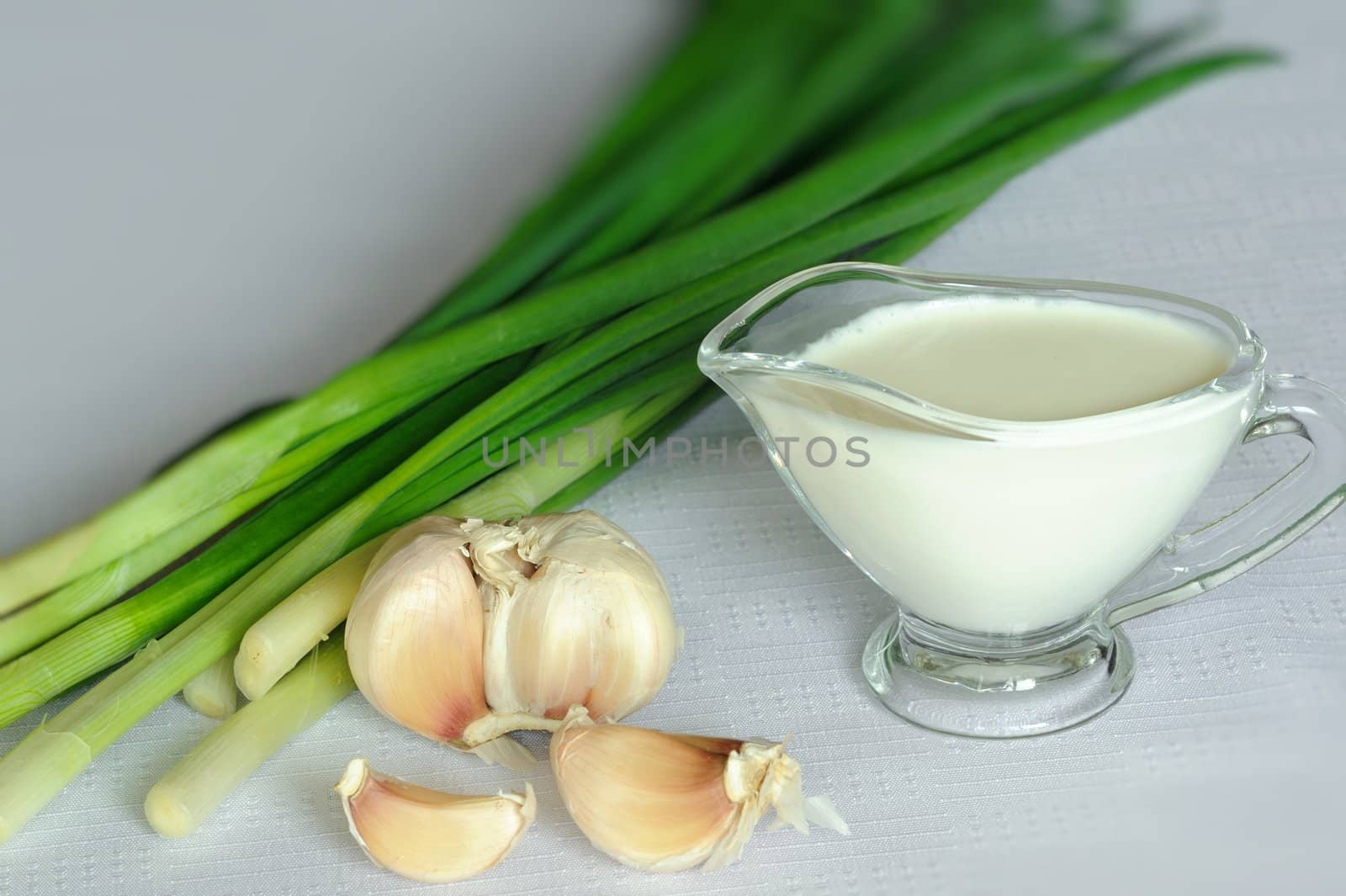 An image of white souce and green onion with garlic