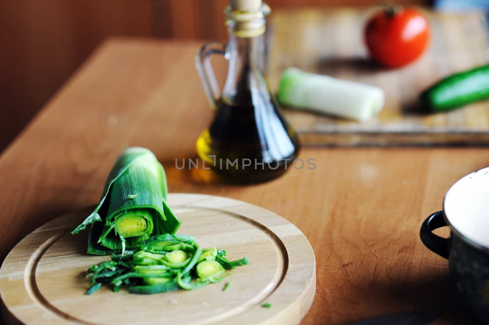 An image of green leek on a wooden board