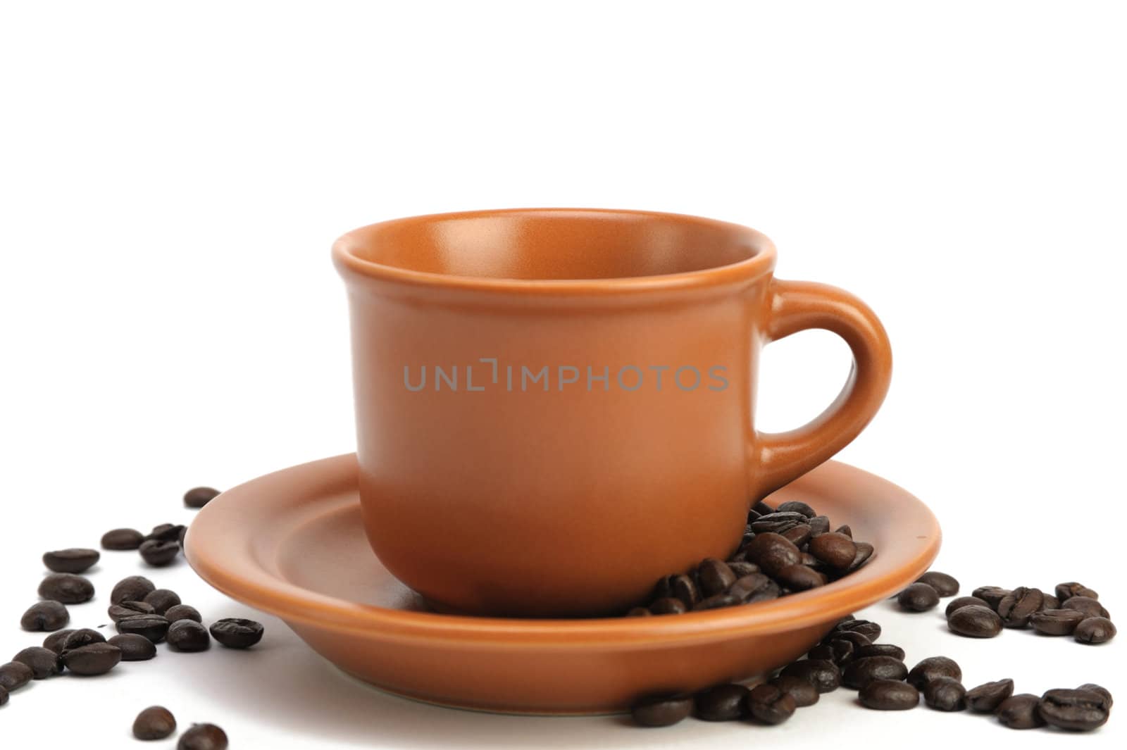 An image of a cup and a saucer with coffee beans