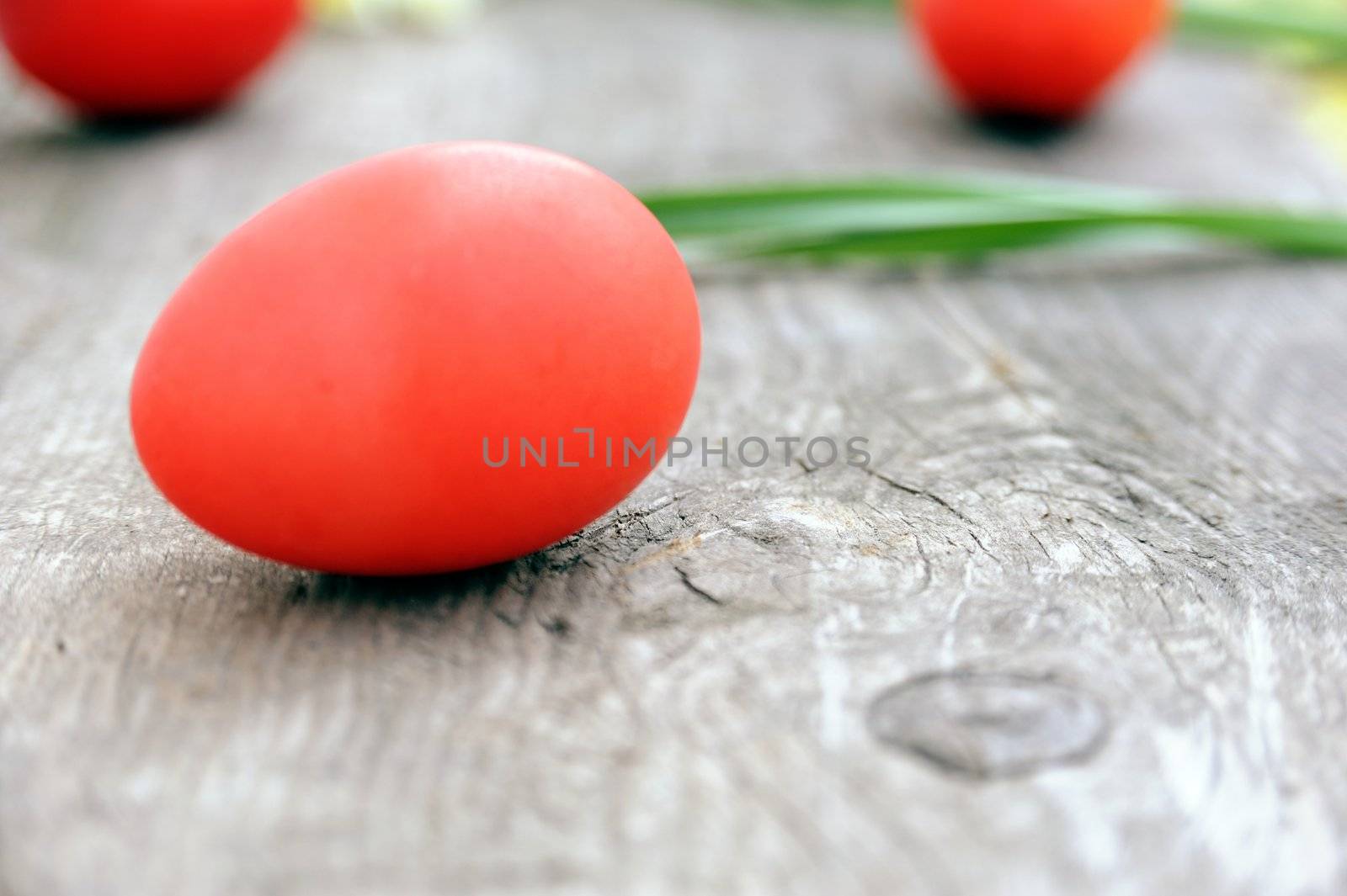 An image of three red eggs on the wood