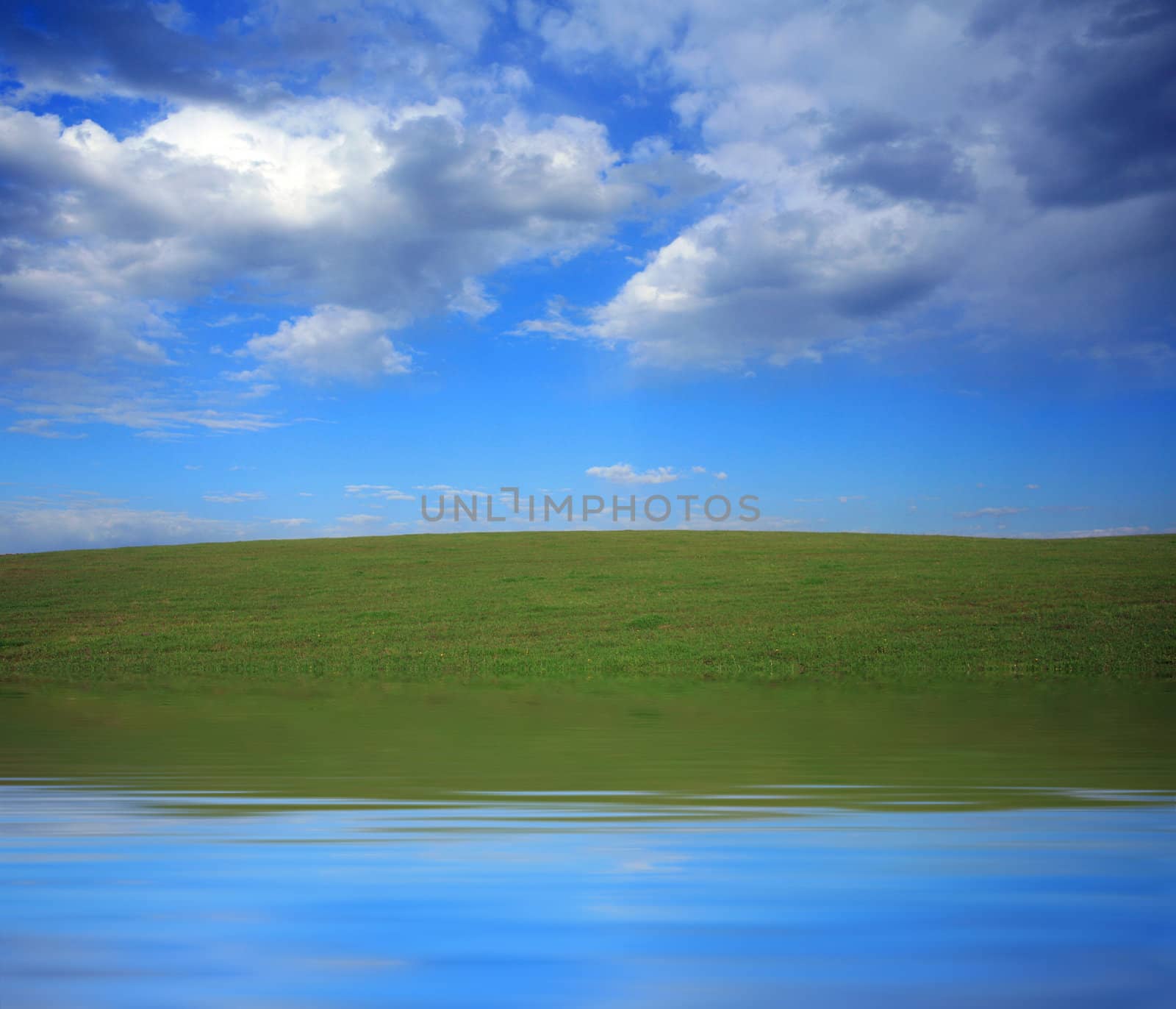 An image of field and blue sky with clouds