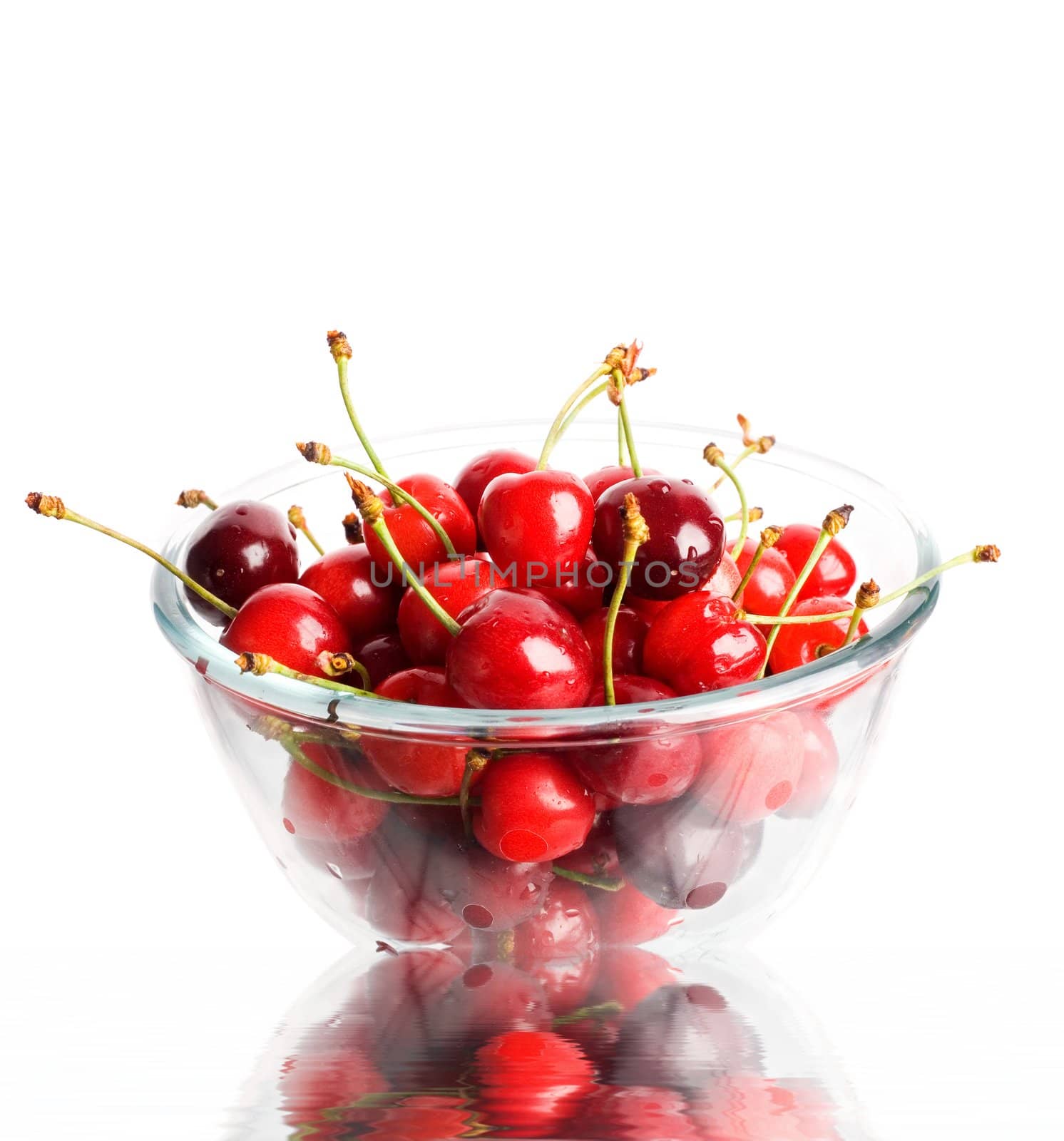 An image of ripe red cherries in a glass cup