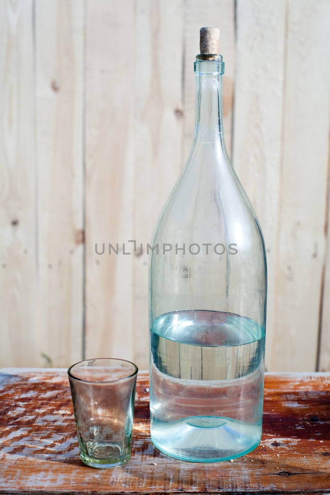 An image of a half-full bottle and a glass