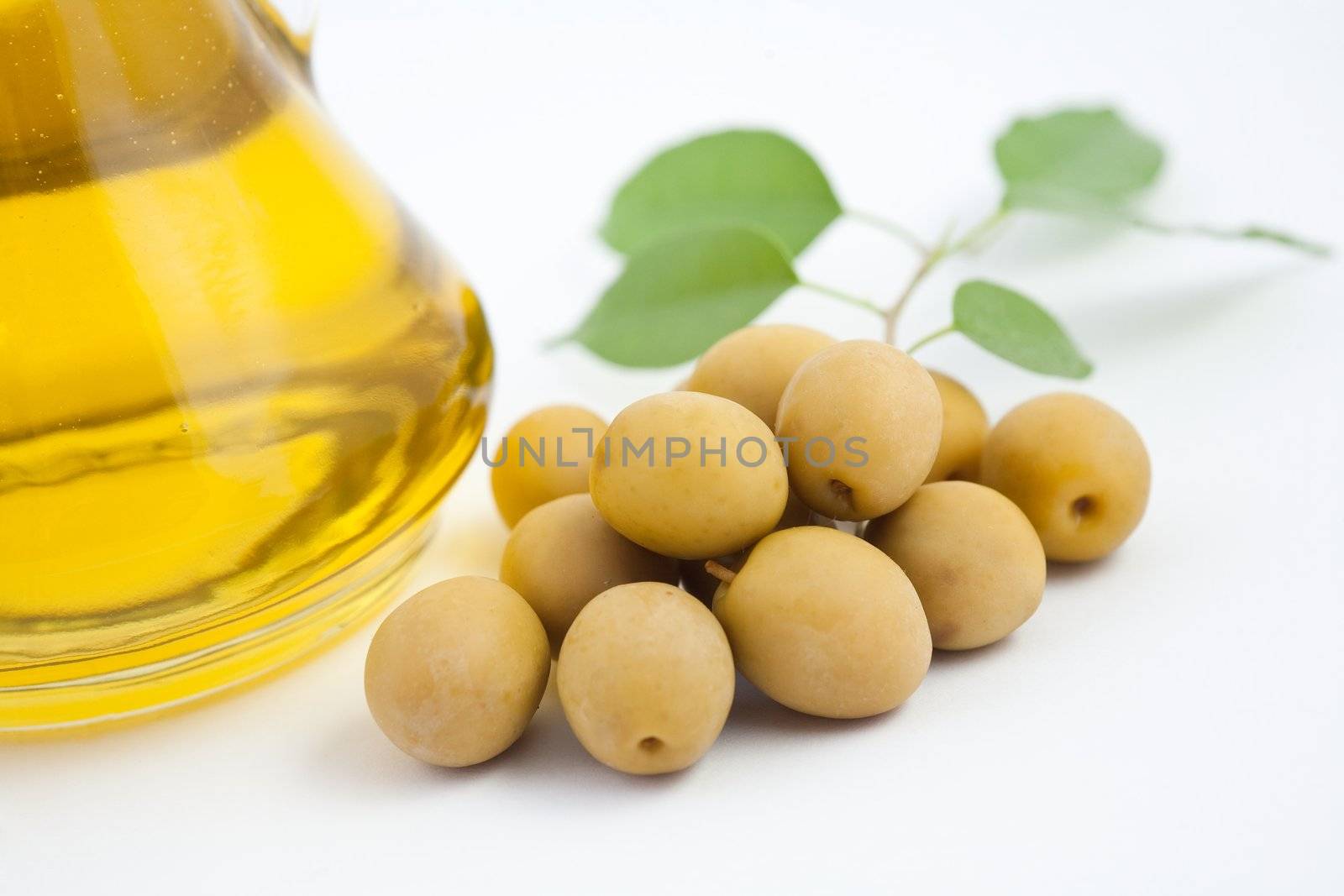 Green olives and a bottle of oil on the table