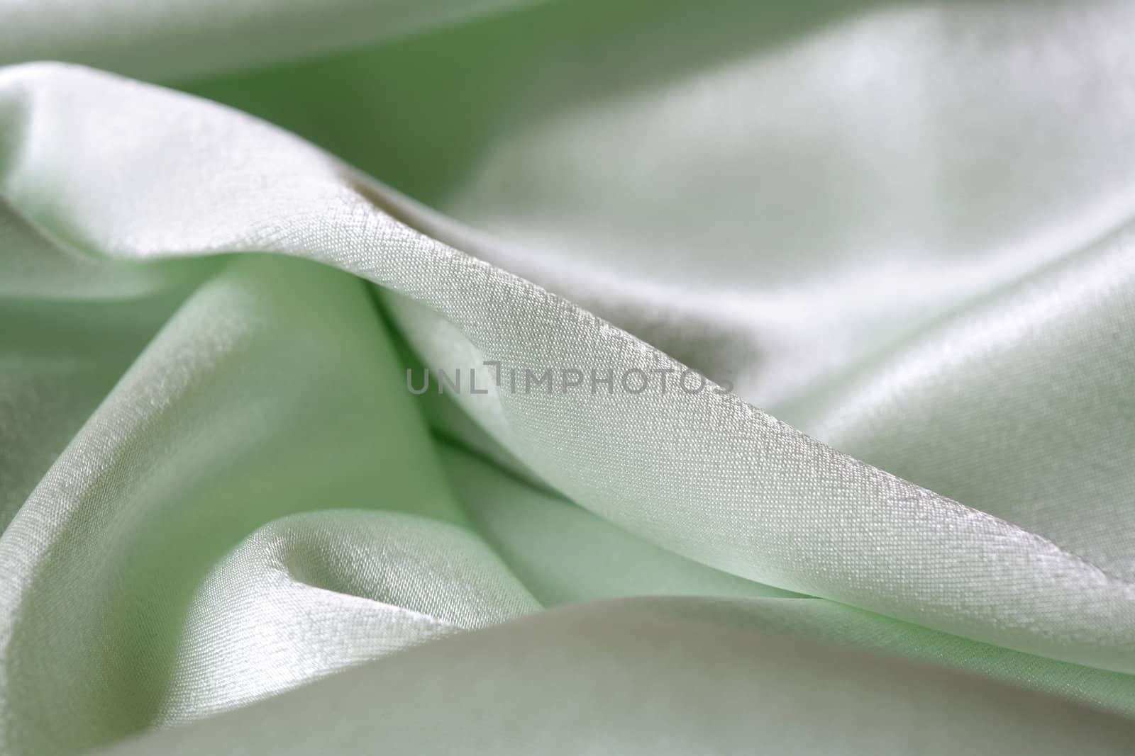 An image of folds of green shine fabric