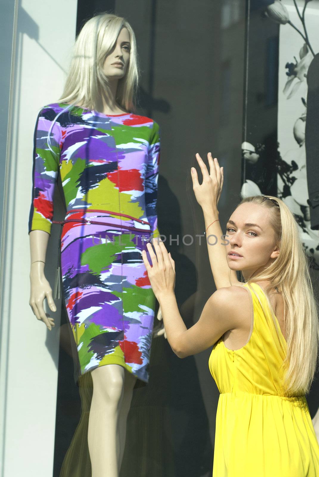 a blonde in yellow dress near the show-window and dummy