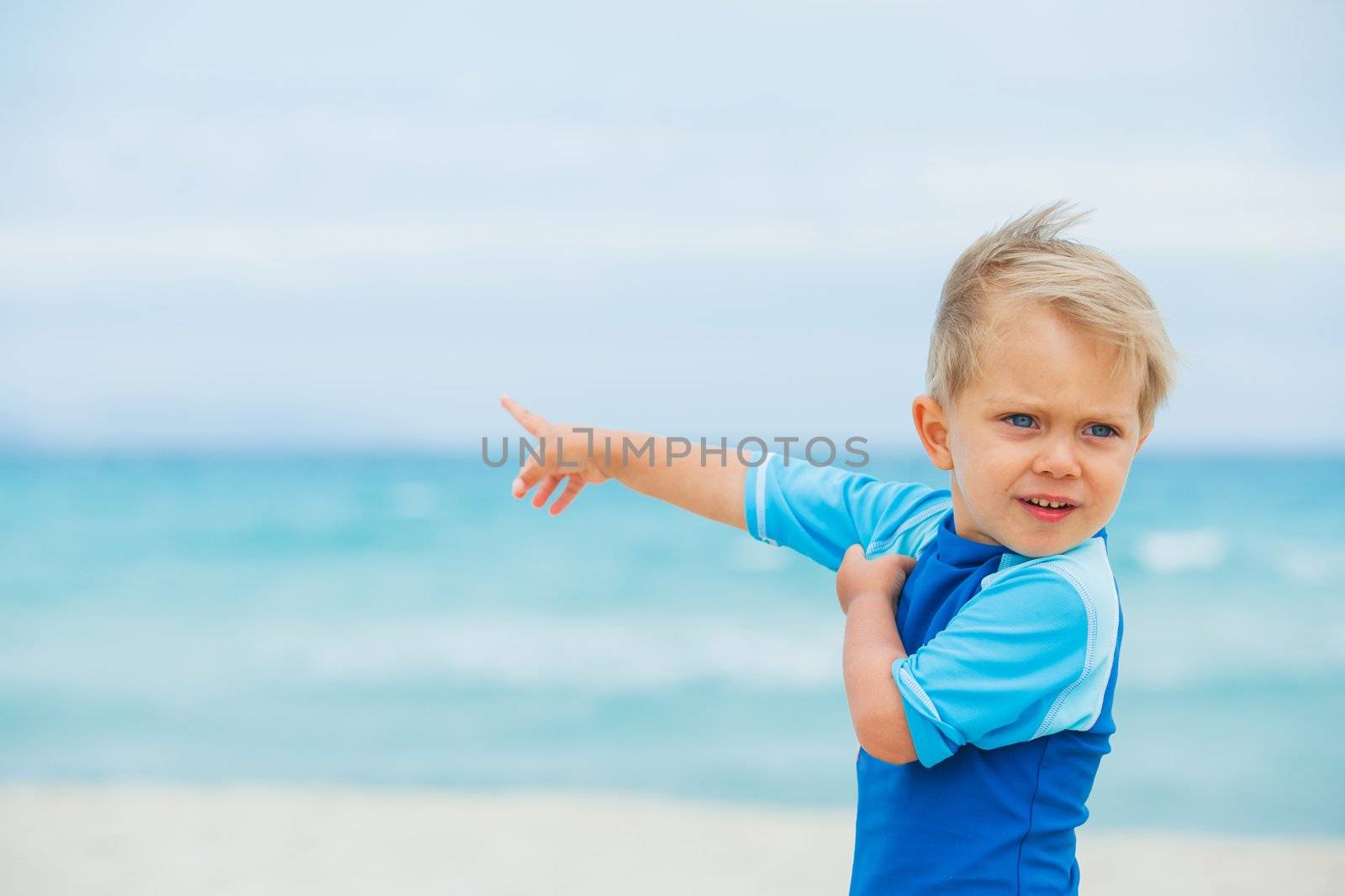 Back view cute 2 years old boy runing on tropical beach