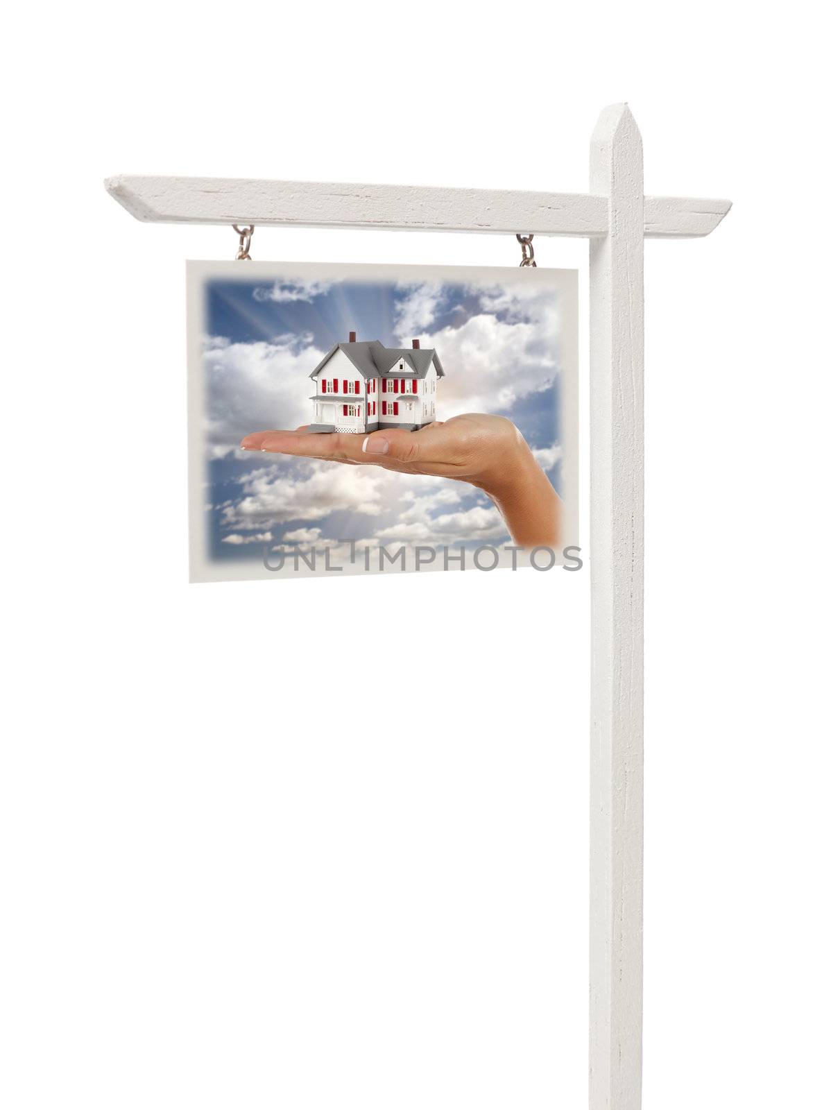 Isolated Real Estate Sign with Clipping Path - Hand Holding House in Front of Clouds, Sky and Sun Rays.