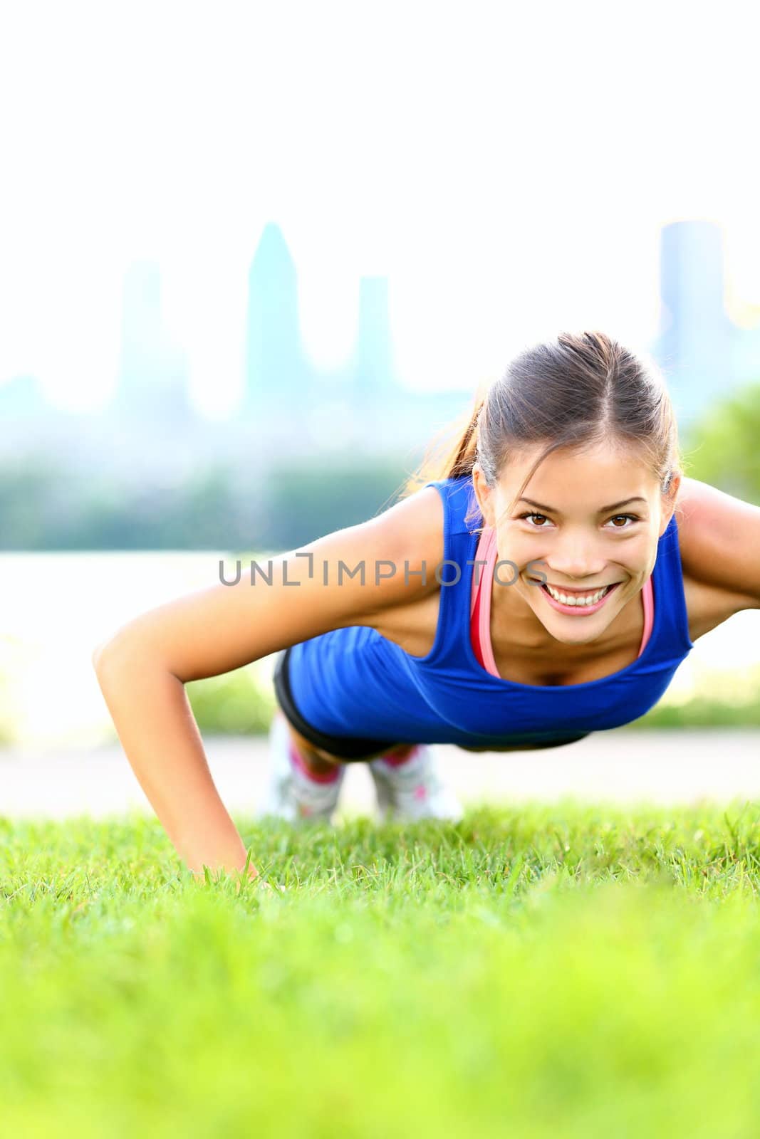 Exercise woman doing situps in outdoor workout training. Asian sport fitness woman smiling cheerful and happy looking at camera.