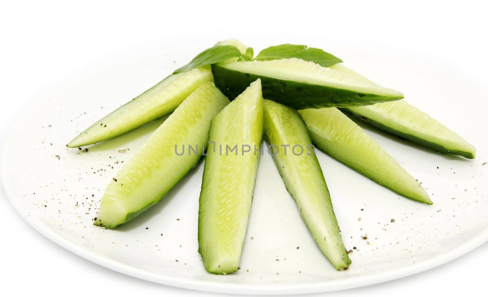 sliced cucumber on a plate on a white background